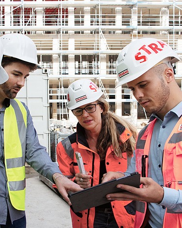 STRABAG and suppliers on construction site with tablet